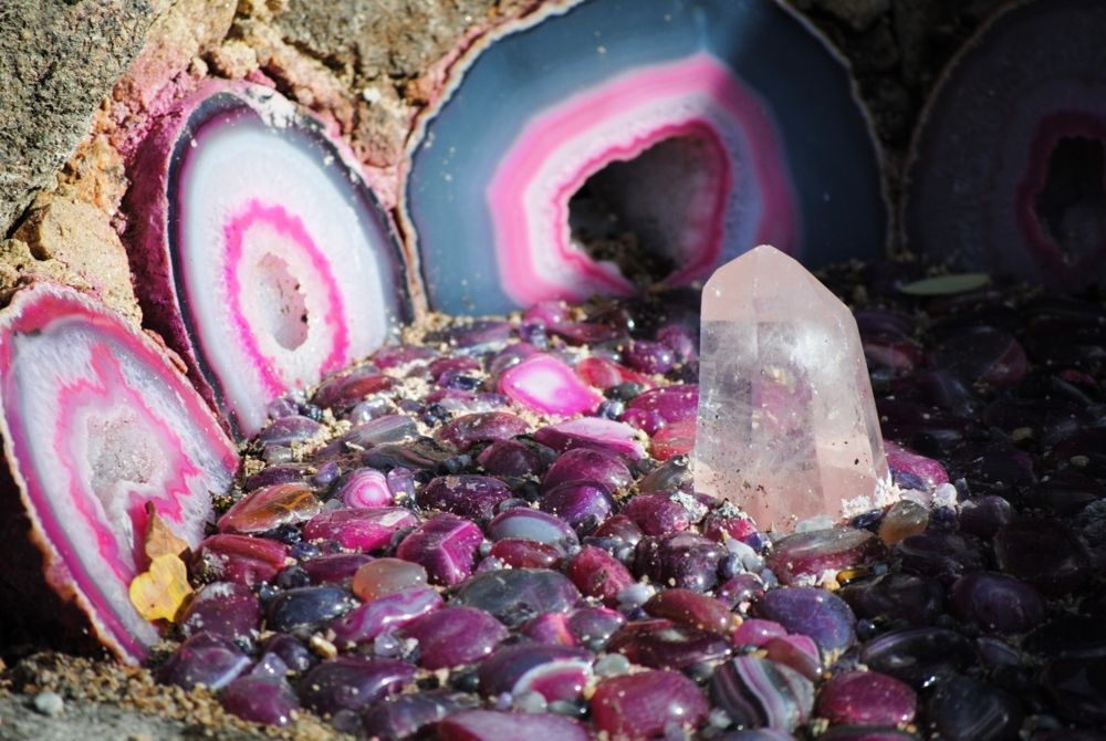 Geodas y rodajas de ágata en tonos rosa junto a puntas de cuarzo