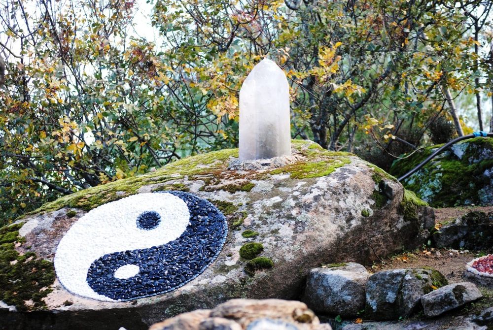 Mosaico de piedras formando un Yin-Yang sobre un bollo de roca
