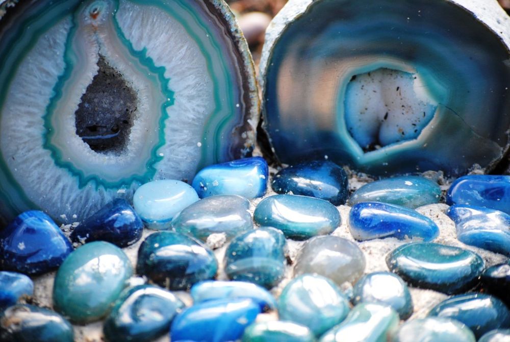 Geodas de ágata azul con piedras pulidas delante
