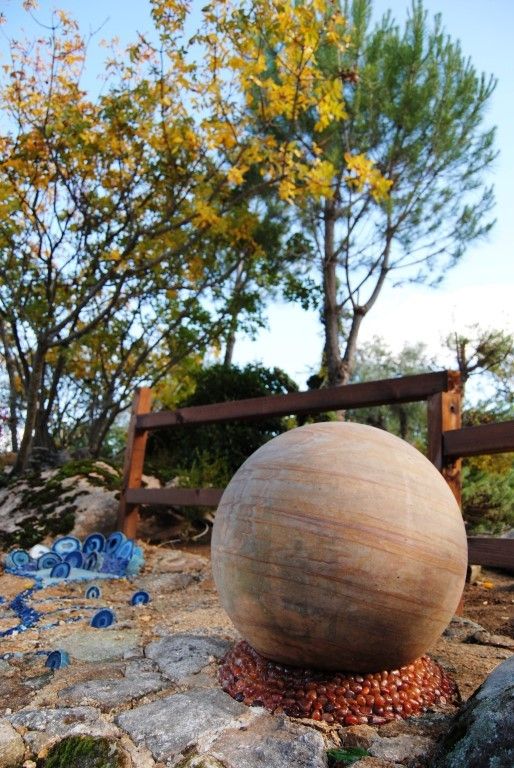 Esfera de piedra pulida rodeada de bolas de mineral